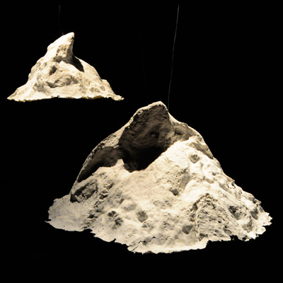 Two papier-mache mountains floating on a black background