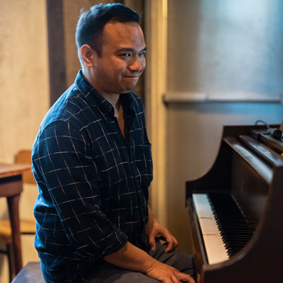 Victoria Noriega, seated at a piano smiling