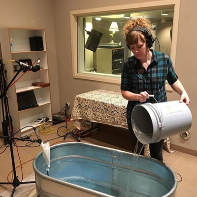Erin Elyse Burns fills a tank with water in the studio at Jack Straw