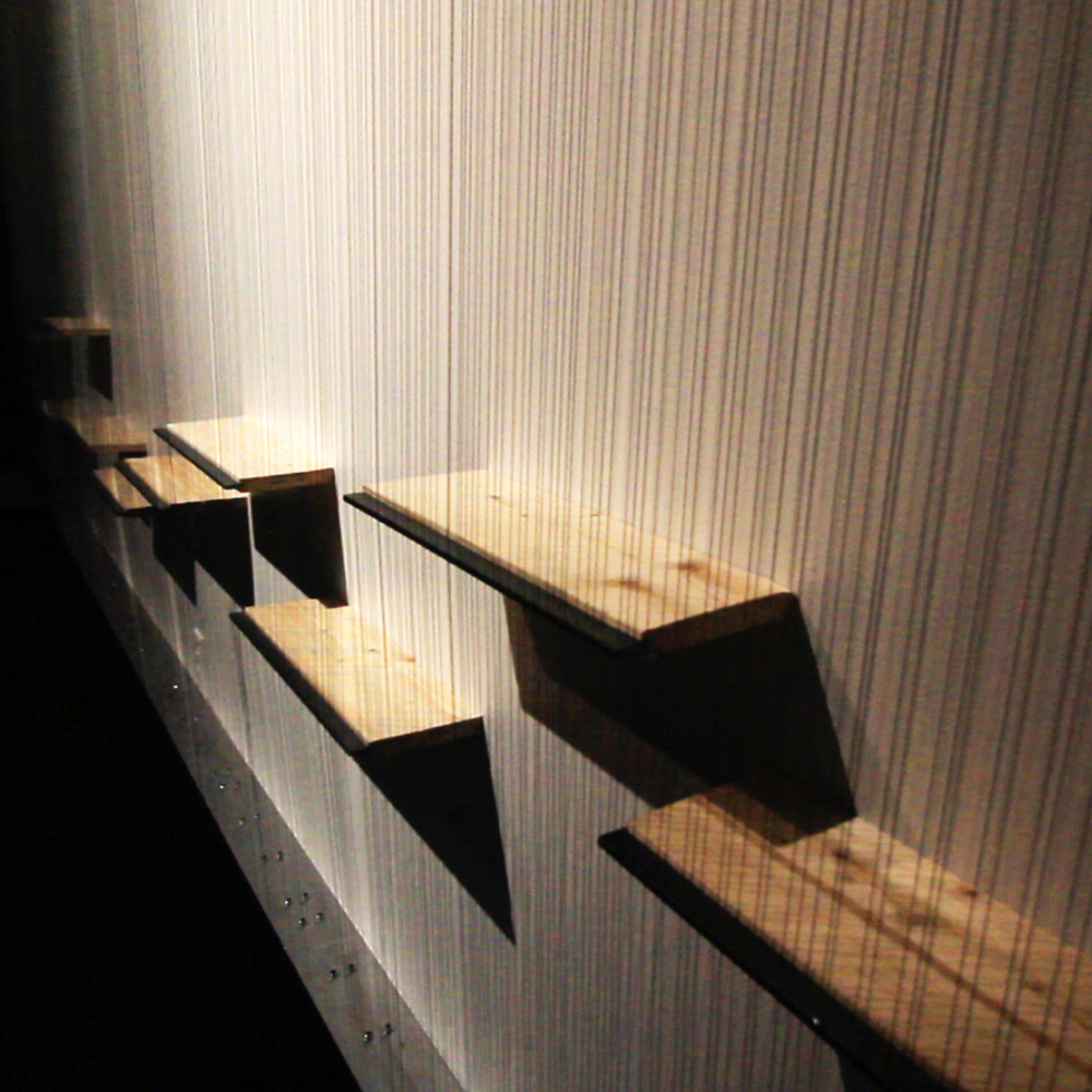 Detail of Large String Array installation, strings stretching down a wall across metal bridges