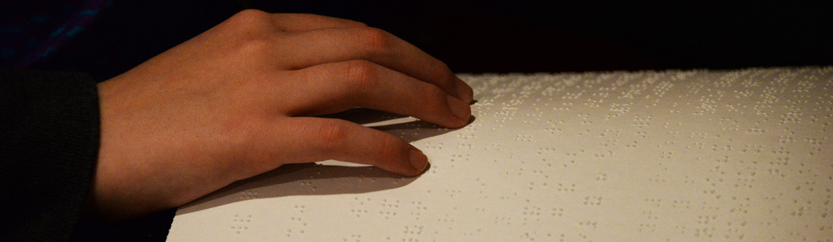 A hand over a page of braille