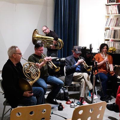 Five brass instrument players in the studio at Jack Straw