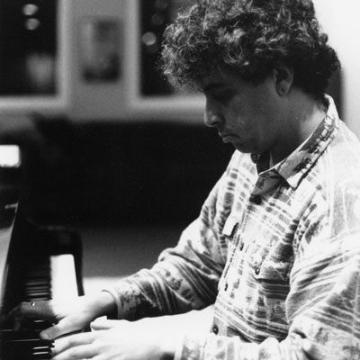 Black and white photo of Jovino Santos Neto playing piano.