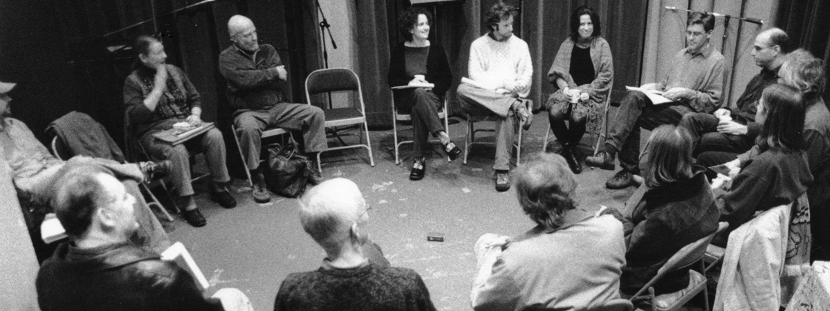 Black and white photo of Jack Straw writers, curator, and staff sitting on chairs in a circle.