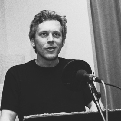 Black and white photo of Arne Pihl, reading at a microphone