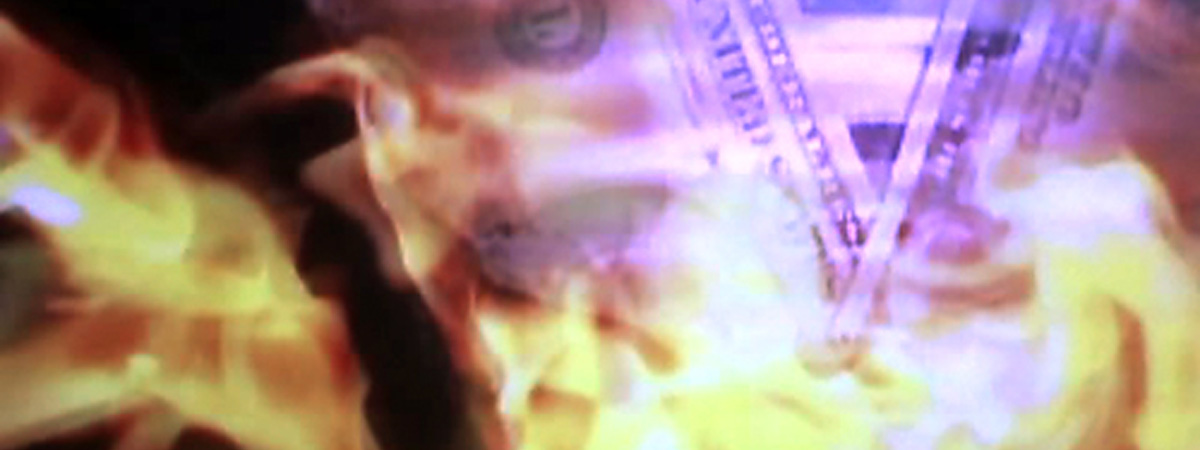 A video image of dollar bills and flames.