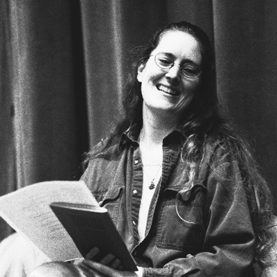 Black and white photo of Danika Dinsmore holding a book and a piece of paper.