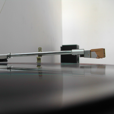 A record player stylus hovers over a spinning record.