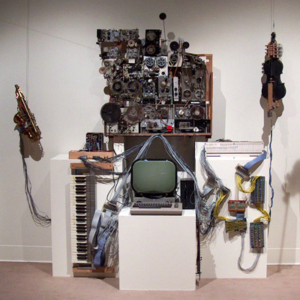 An array of old and contemporary technology and musical instruments arranged on a wall.