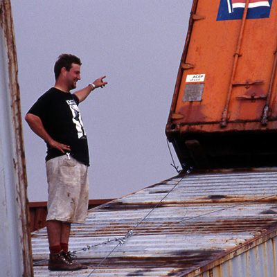Christian French standing on top of a shipping container, pointing to another leaning on top of it.