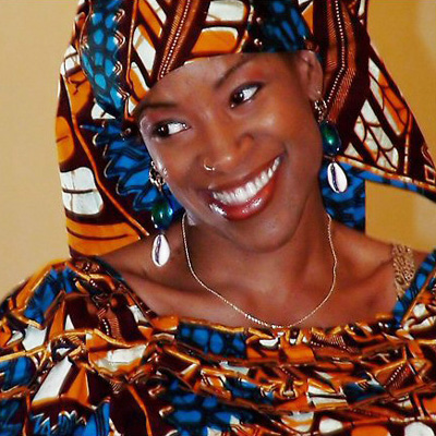 Portrait of Franchesska Berry, wearing colorful matching patterned headscarf and clothing.