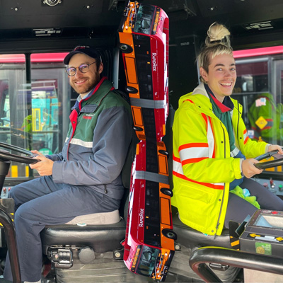 Paired photos of Kelsen Caldwell and Ross Kirshenbaum, each sitting in the driver's seat of a bus. King County Metro buses are collaged vertically in the middle.