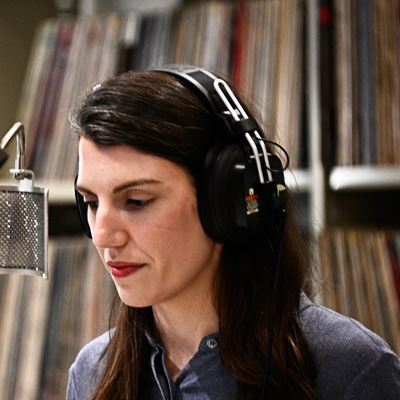 Helen Anderson at a microphone, wearing headphones.