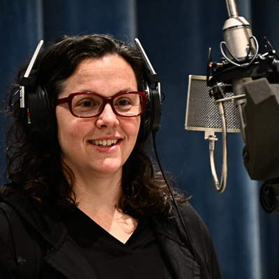 Jessica Gigot at a microphone, wearing headphones.