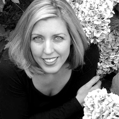 Black and white photo of Kelli Russell Agodon, with flowers to the right.