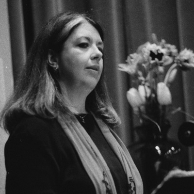 Black and white photo of Rebecca Meredith, with flowers in the background.
