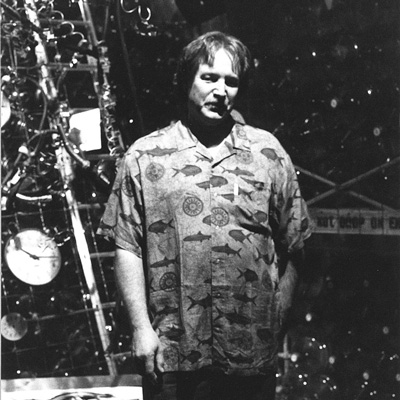 Black and white photo of Jim Pridgeon standing in front of an art installation.