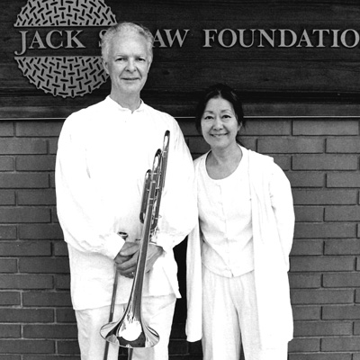 Black and white photo of Stuart and Renko Dempster, Stuart holding a trombone.