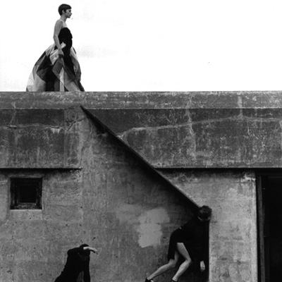Black and white photo of three dancers performing on a concrete structure at Fort Worden.