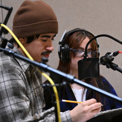 Carlos Nieto and a student in a recording studio with microphones.