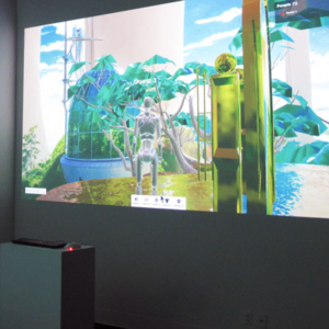 A projection of a video game screen on a gallery wall. A keyboard and mouse on a pedestal in the foreground.