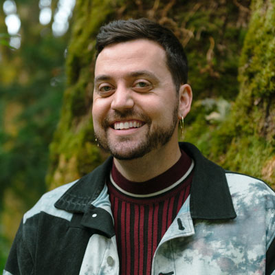Portrait of David Strand. A moss-covered tree is in the background.